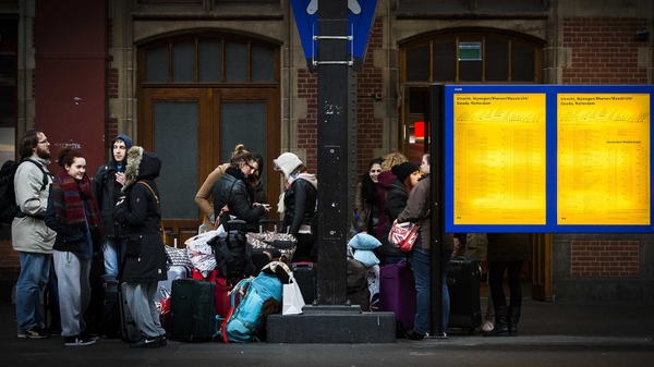 Rail passengers stand around during a major power outage at Amsterdam Central Station