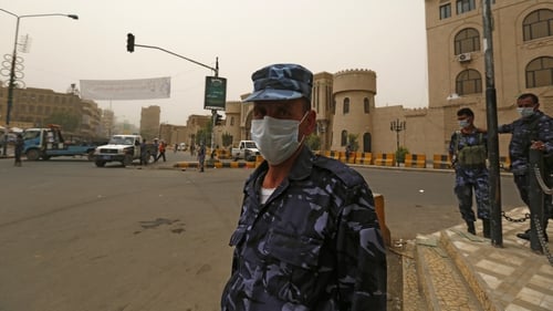 Yemeni policemen wear surgical masks to protect themselves from a sandstorm at a checkpoint in Sanaa