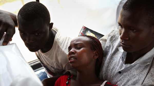 A rescued student (C) is overcome by grief as she waits to be transported home from Garissa town