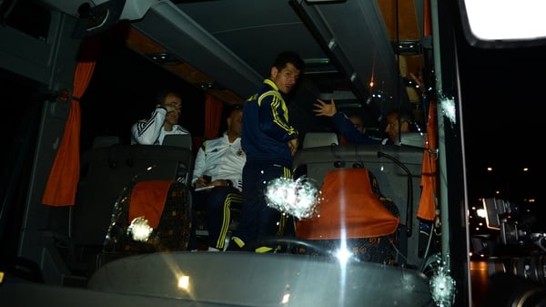Football player Emre Belozoglu (C) and head coach Ismail Kartal (R) inside the bus following the attack