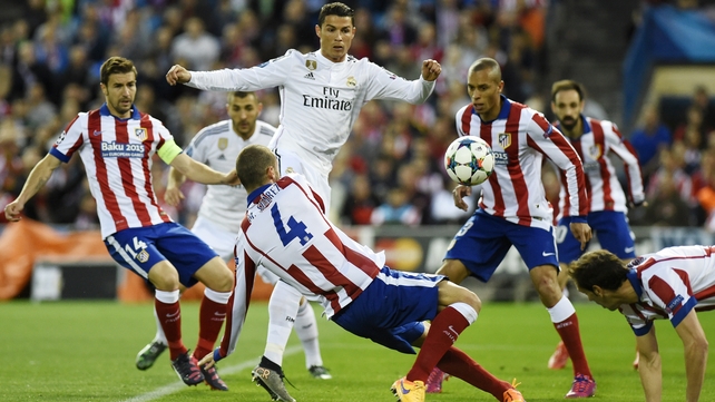 Cristiano Ronaldo is tackled by Atletico Madrid midfielder Mario Suarez 