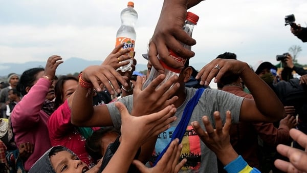 Water is distributed to Nepalese people at a camp set up in the wake of the earthquake
