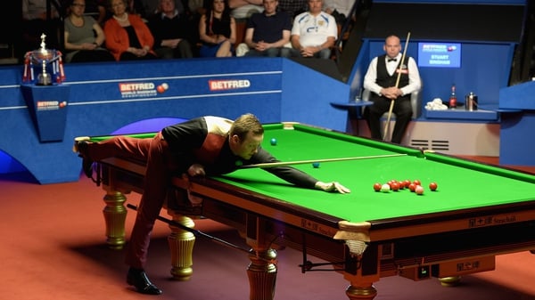Shaun Murphy takes a shot as Stuart Bingham watches on, with the World Championship trophy in the backround