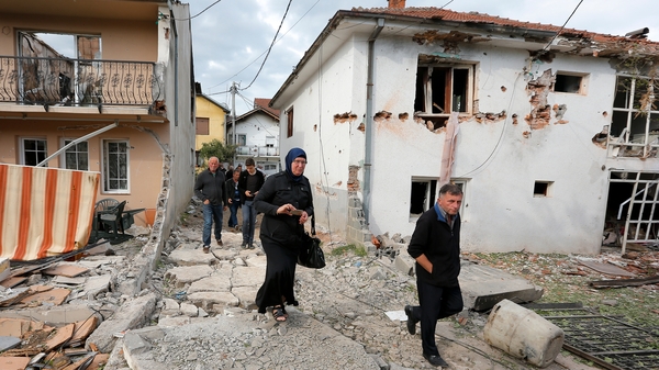 Residents visit destroyed houses in a neighborhood where a shooting took place