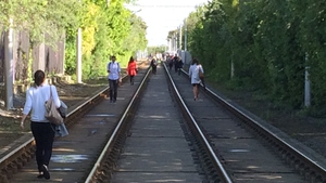 People walk along the Luas Green Line track at Beechwood Avenue