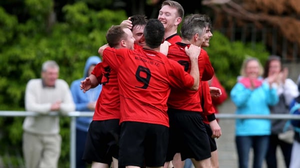 Dylan O'Driscoll of Killester celebrates with team-mates after scoring his side's third goal