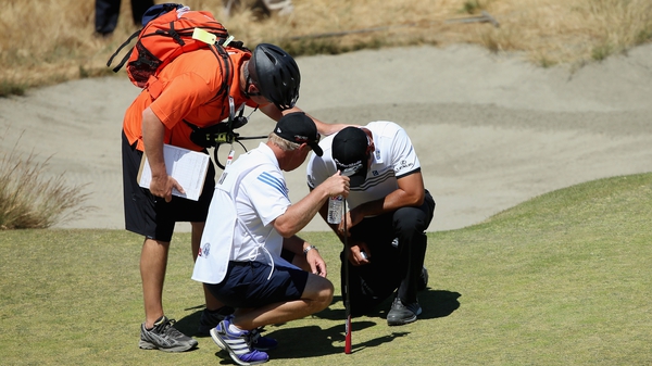 Jason Day tended to after falling due to dizziness on the ninth hole