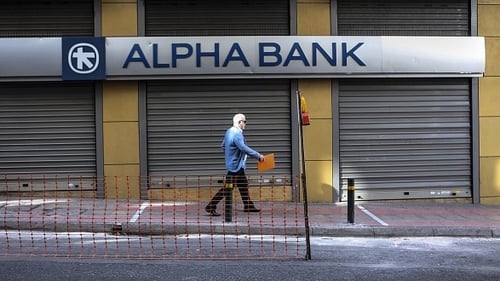 A man walks past a closed bank in Athens today
