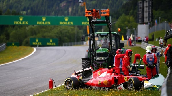 Marshalls prepare to remove Kimi Raikkonen's Ferrari after he crashed during the Formula One Grand Prix of Austria