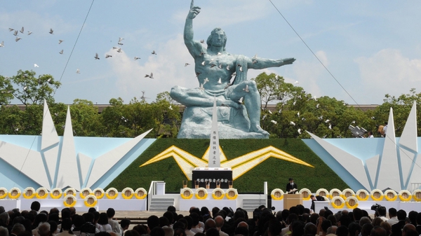 Doves fly over the Peace Statue during the memorial ceremony in Nagasaki