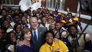 George Bush and his wife Laura Bush take a selfie with Asia Muhaimin, the Warren Easton High School band director, and the rest of the marching band during a visit to the school
