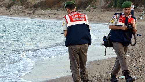 Turkish police at the scene where the body of a three-year-old refugee washed up on a beach