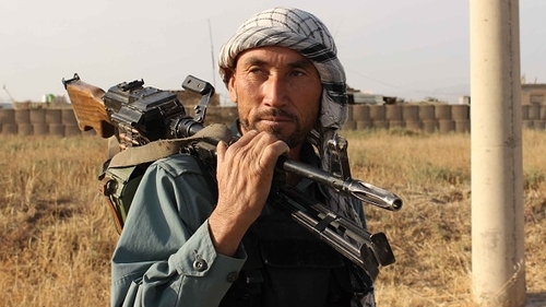 An Afghan policeman holds a gun on his shoulder a day after Taliban insurgents overran the strategic northern city of Kunduz