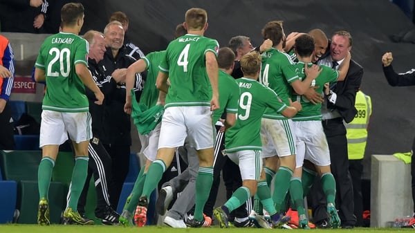Michael O'Neill is mobbed by his Northern Ireland players after securing qualification to Euro 2016
