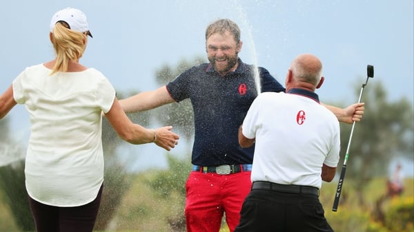Andy Sullivan is sprayed with champagne on the 18th