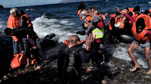 A man reacts as he arrives, with other refugees and migrants on Lesbos after crossing the Aegean sea from Turkey
