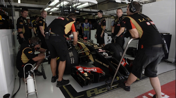 The Lotus team carry out repairs in the pits