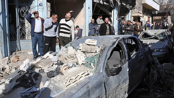 Syrians gather at the site of a car bomb explosion in Homs