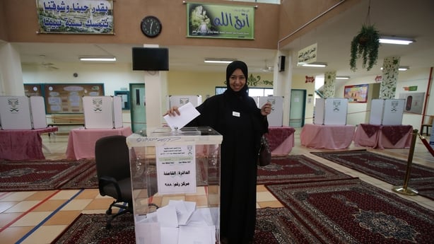 A Saudi woman casts her vote for the municipal elections at a polling station