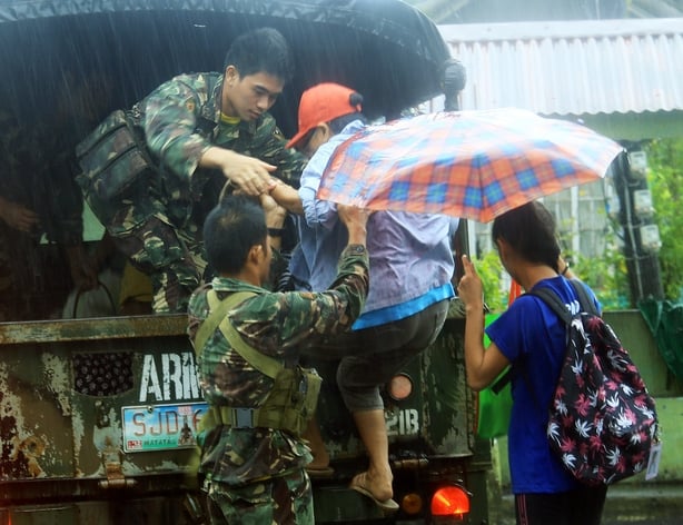 Military personnel evacuate residents from a village in the city of Legaspi