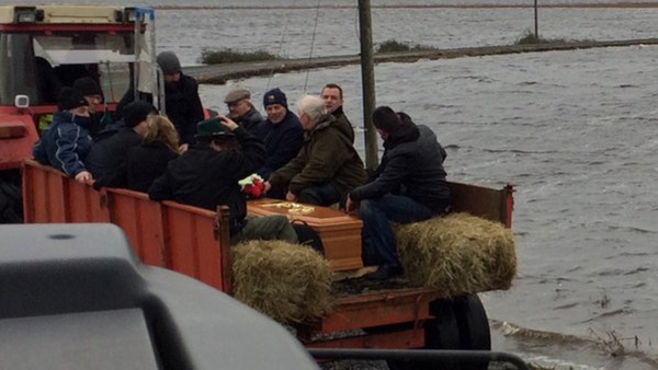 Several neighbours and friends assisted in bringing the remains of a deceased man on a tractor through the floods for burial at Saint's Island