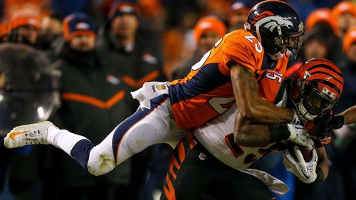 Chris Harris (No 25) of the Denver Broncos leaps on to the back of Giovani Bernard
