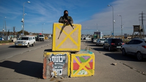 An Israeli soldier stands behind a carrier at Gush Etzion junction following an attack earlier this week