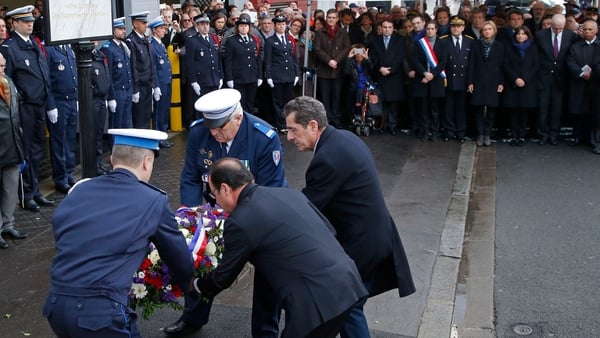French President Francois Hollande (C, back to camera) and the mayor of Montrouge, Jean-Loup Metton (R), lay a wreath of flowers honouring policewoman Clarissa Jean-Philippe, in Montrouge, south of Paris