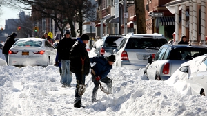 People work on digging out their cars following the snow storm in Brooklyn, New York