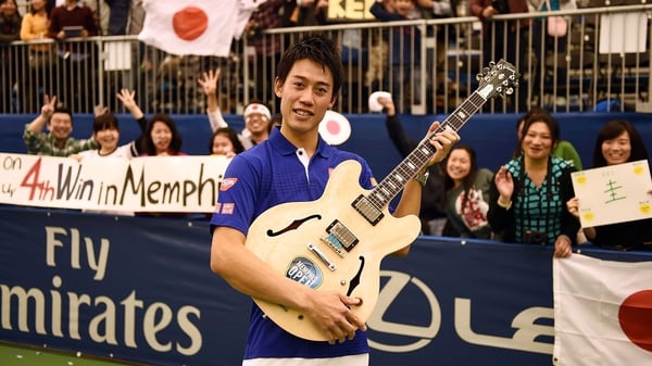Kei Nishikori poses with a less-than-usual trophy in Memphis