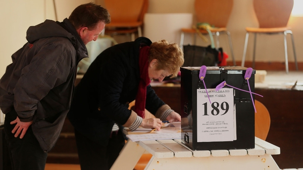 Presiding Officer Carmel McBride checks the name of a voter (left) on Inis Bó Finne