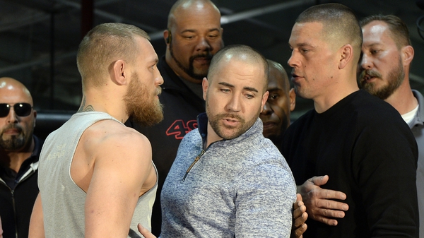 UFC featherweight champion Conor McGregor (L) and lightweight contender Nate Diaz (R) are held apart