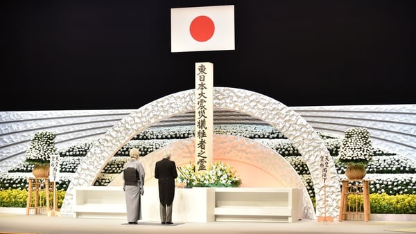 Emperor Akihito with Empress Michiko deliver an address in front of an altar for the victims