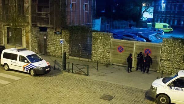 Belgian police wait in a street outside the sealed-off area in Molenbeek