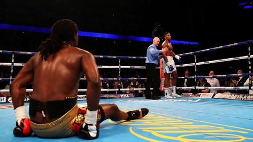 Anthony Joshua is ordered back to his corner by the referee as Charles Martin sits on the canvas