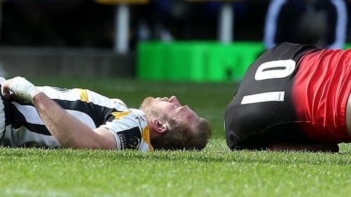 Dan Robson (l) of Wasps lies injured after a tackle by Owen Farrell (r)