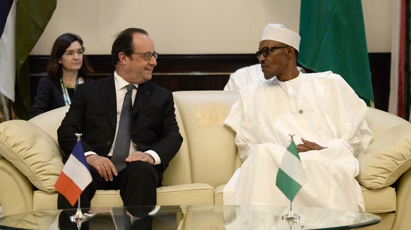 French President Francois Hollande speaks with Nigerian President Muhammadu Buhari during a meeting at the presidential Palace in Abuja, Nigeria