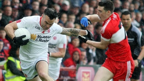 Tyrone's Cathal McCarron holds off Derry's Gareth McKinless
