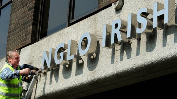 The writing's off the wall - workers remove signage from outside Anglo Irish Bank in Dublin