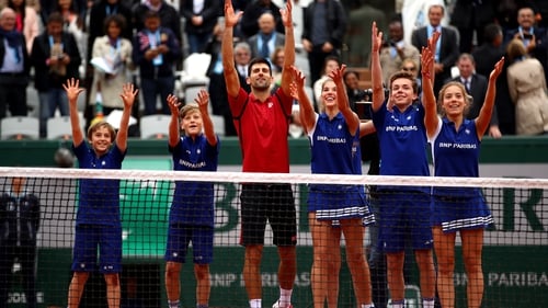 Novak Djokovic celebrates his French Open semi-final win with the ball boys and girls