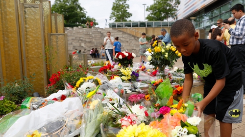 A young boy leaves flowers in tribute to Muhammad Ali outside the Muhammad Ali Center in Louisville, Kentucky
