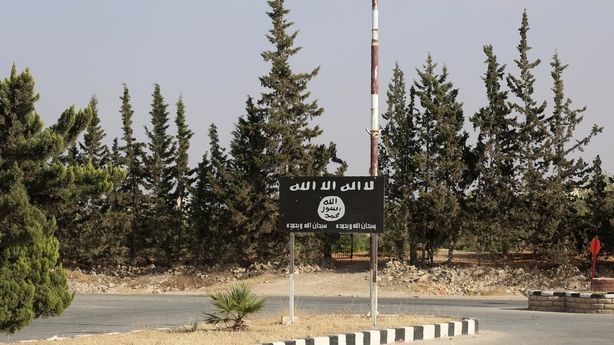 An Islamic State group flag is seen on a road in Manbij