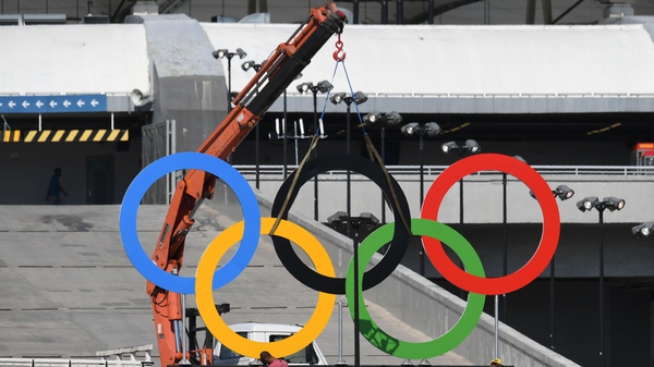 Workers set the Olympic rings outside the Maracana stadium in Rio de Janeiro