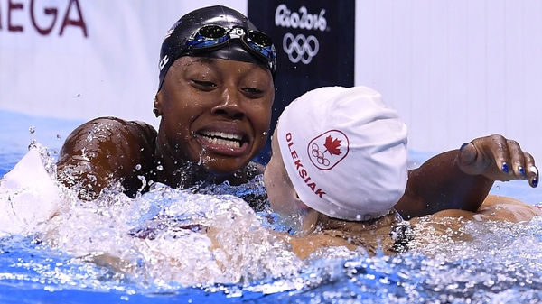 USA's Simone Manuel (L) and Canada's Penny Oleksiak react after they shared gold in the Women's 100m freestyle final