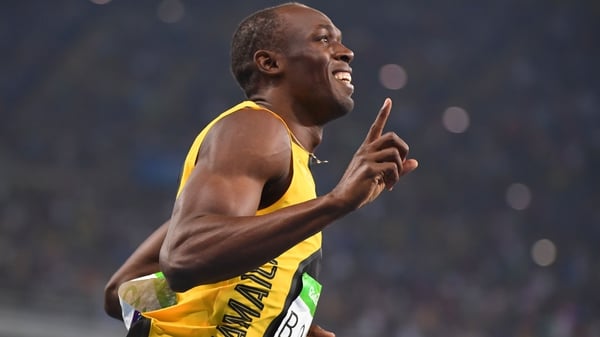 Usain Bolt celebrates after crossing the line