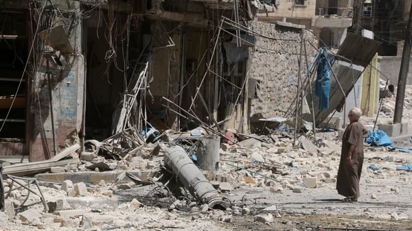 A resident of the Tariq al-Bab neighbourhood of Aleppo, inspects the damage caused by air raids