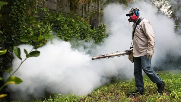 A mosquito control inspector sprays pesticide to kill mosquitos in the Miami Beach area