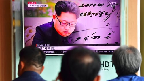 People watch file footage of North Korean leader Kim Jong-Un at a railway station in Seoul