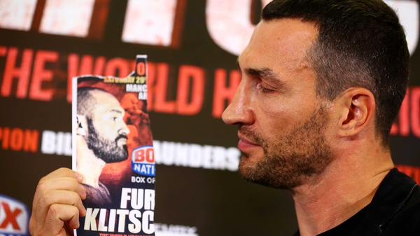 Wladimir Klitschko poses with an image of Tyson Fury