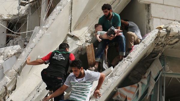 Syrian men remove a baby from the rubble of a destroyed building in Aleppo yesterday